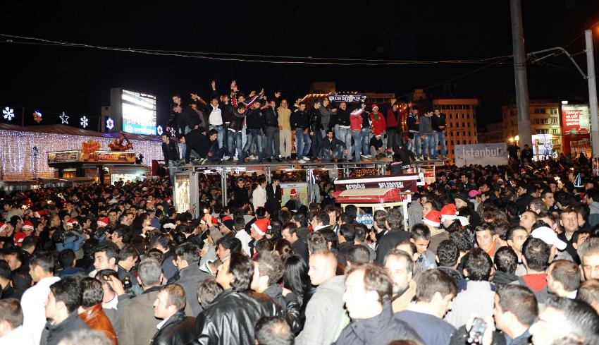 The crowds at Taksim overflow the space on the pavement and some New Year's partiers are focred to take refuge atop a tram shelter