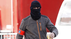 A masked Belgian police officer outside Kurdish broadcaster ROJ
